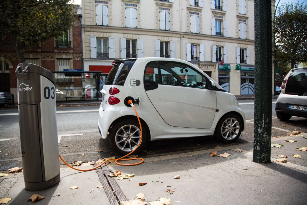 Voiture électrique en train d'être rechargée dans les rues de Paris